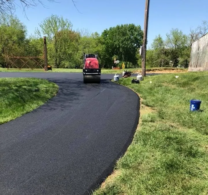 Light aggregate chip seal rural driveway curving through Texas brush and small trees